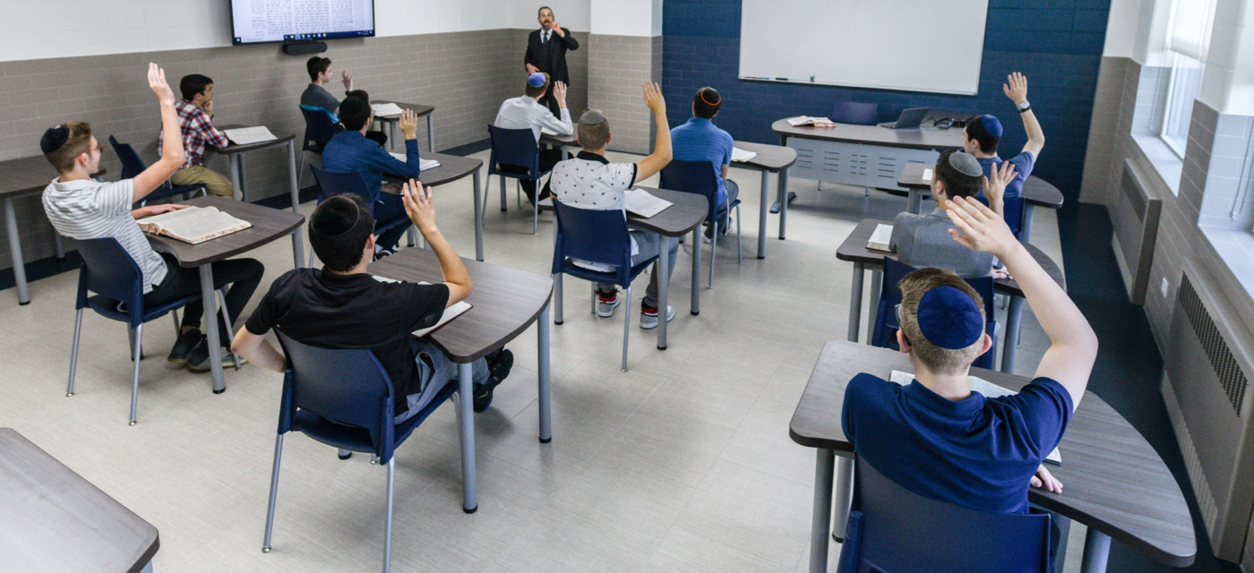 students raising hands in class