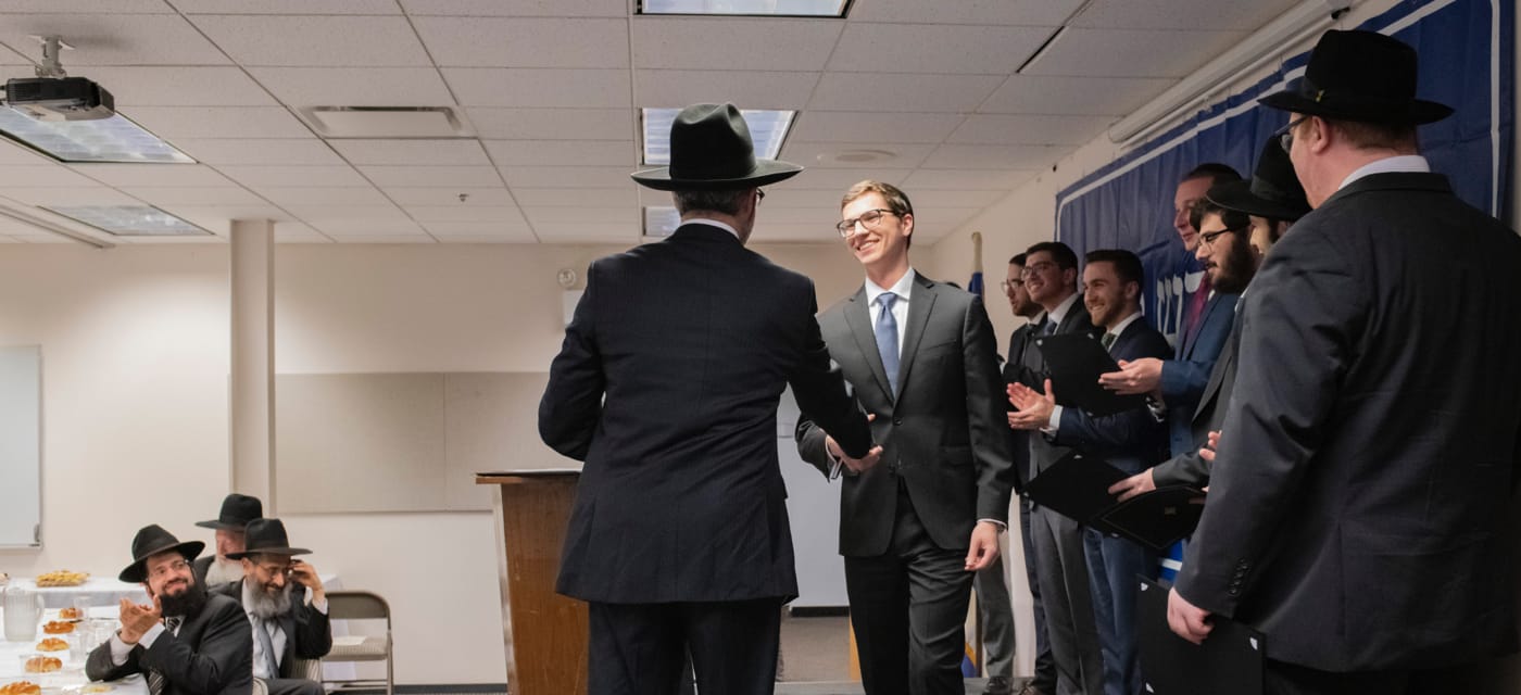 male student shaking hand accepting award