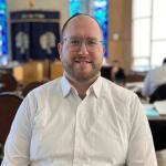 R Yosef Feldman sitting at table in temple