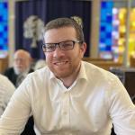 Rabbi Meir Sears sitting at table in temple